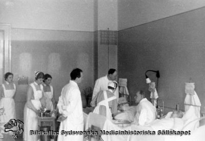 Prof. Gustaf Petrén går rond, sittande på patientens sängkant
Påskrift: "Kir. F mars 1937", dvs rond på kirurgens avdelning F i mars 1937. Omonterat foto.
Nyckelord: Kapsel 02;Regionarkivet;Lasarettet;Lund;Professor;Gustaf;Petrén;Rond;Kirurgisk;Klinik;;1937;