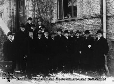 Styrande höga herrar vid Lasarettet i Lund under något av 1900-talets första decennier
Foto vid entrétrappan till gamla ögonkliniken på södra lasarettsområdet. På trappan förmodligen Gustaf Petrén (längst till vänster på ett av trappstegen, i glasögon), eller kanske hans bror Karl. Nr 4 från höger kan vara Karl Otto av Klercker, pediatrikprofessor eller Elis Essen-Möller. Nr 6 är förmdligen Einar Sjövall, patologen.Möjligen kan den skäggige t hö om Petrén vara Viktor Odenius.
Ögonklinikens byggnad hyste också i början lasarettskontor och direktionsrum. Det senare flyttades någon gång efter 1918 till det s.k. portvaktshuset vid Allhelgona Kyrkogata. Bilden är rimligen tagen i samband med något sammanträde med styrande herrar i sjukhusdirektion eller landsting på 1920-talet. 
Nyckelord: Foto;Omonterat;1920-talet;Gustaf;Petrén;Karl;Otto;av Klercker;Elis;Essen-Möller;Einar;Sjövall;Viktor;Odenius