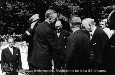 Barnkliniken i Lund invigs 1952 av H.M. Konungen
Hans Majestät Konung Gustav VI Adolf hälsar på landstingsmän inför invigningen av barnsjukhuset i Lund 1952 och besök på radiologiska kliniken i Lund. Lasarettsdirektör Arne Johansson i bildens nedre vänstra del, ur fokus. Kungens chaufför bakom honom gör honnör, galonerad.
Nyckelord: Kapsel 18;Barnsjukhus;Lasarett;Lund;Lasarettsområde;Norra;Område