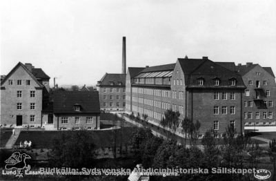Ortopediska kliniken i Lund nära 1900-talets mitt
Ortopediska kliniken med den glastäckta solningsverandan åt söder. I bakgrunden öronkliniken, till vänster reumatologiska kliniken. Publicerad i Flaum 1968, sid.219, i lätt beskuren form. Foto före reumatologens tillbyggnad under första halvan av 1950-talet.
Nyckelord: Kapsel 18;Norra;Området;Lund;Lasarett