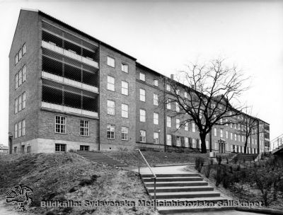 Psykiatriska kliniken: efter om- och tillbyggnaden år 1951, från sydväst 
Sedan psykiatrin flyttat till gamla sköterskeskolan (SSSH) kallas huset nu år 2011 Wigerthuset, och innehåller vitt skilda funktioner och mottagningar i öppen vård. Publicerad i Flaum 1968 på sid. 222. Originalfoto, Monterat
Nyckelord: Kapsel 18;Lasarettet;Lund;Norra;Området
