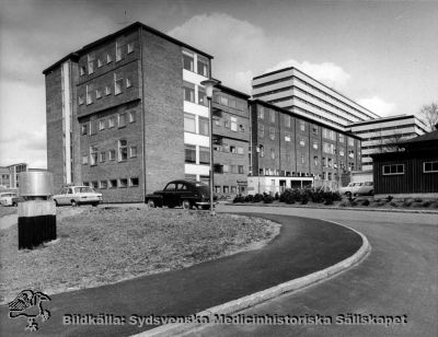 Radiologiska kliniken - Jubileumskliniken - efter om- och tillbyggnaden 1963 - 1965. 
I bakgrunden centralblocket. Publicerad i Flaum 1968 sid 256. Foto från sydväst mellar 1965 och 1968. Omonterat.
Nyckelord: Kapsel 18;Onkologi;Lasarett;Lund;Norra;Området
