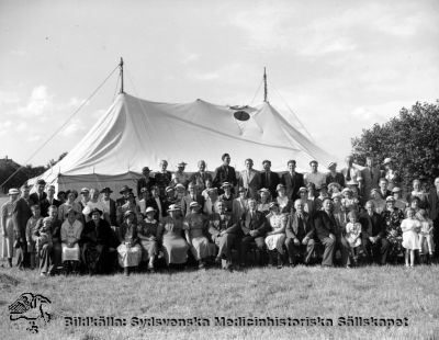 Mötestält med mötesdeltagare, kanske på St Lars
Påskrift: "Resor". Ingen annan märkning. Originalfoto. Ej monterat. Klädstilen talar för att fotot är från 1900-talets första halva. Personerna i bilden är troligen personal, mindre troligt patienter.
Nyckelord: St Lars;Personal;Utflykt;Tält;Tältmöte;Kapsel 19