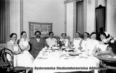 Födelsedagskalas på St Lars mentalsjukhus i Lund.
Fotografiskt vykort av samma utförande som flera andra, näraliggande i en kapsel med bilder från St Lars i Lund, varav ett är daterat till 1921. Detta kort är rimligen från ungefär samma tid. Det saknar frimärke och poststämpel, och har alltså aldrig varit postbefordrat. Påskrift: "Olsson (skötte Tranan och fåglarna i dammen) fyller år. Konvalescentavd. Östra sjukhuset".  Originalfoto. Ej monterat
Nyckelord: Kapsel 20;Sköterska;Personal;Mentalvårdare;St Lars;Lund