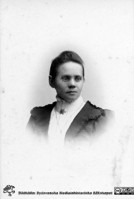 Anna Gustafson (?), sköterska, Lund
Kapsel 21 med bilder från St Lars i Lund. Påskrift: "Anna Gustafson (? - svårtolkat), sköterska, Lund". Originalfoto, ateljé N. Thüring, Lund. Denna fotograf var verksam i Lund runt sekelskiftet 1900. Monterat. Fotot var skadat vid kvinnans högra tinning och har retuscherats.
Nyckelord: Kapsel 21;St Lars;Lund;Personal;Mentalvårdare