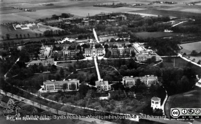 Flygfoto av St Lars Hospital 1928
Kapsel 22 med bilder från St Lars i Lund. Flygfoto av S:t Lars sjukhus, Lund. Påskrift: "1928". Vykort. Originalfoto, Aero material. Ej monterat. Bilden finns (utan firmatext) på sid 127 i Truedsson 1929.
Nyckelord: Kapsel 22;St Lars;Lund;Exteriör;Flygfoto