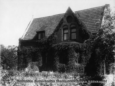 Överläkarvillan vid Lasarettet i Landskrona. 
Överläkarvillan vid Lasarettet i Landskrona i mitten på 1900-talet. Bilden visar västar sidan av huset. På nedre botten hade Gösta Lundh och hans hustru Ingeborg sitt bibliotek. Göstas sekreterare Anna Albrektsson hjälpte till att registrera och sortera.
Nyckelord: Byggnader; Personal; Överläkare