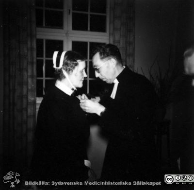 Okänd präst och en sköterska på avtackningsfest
Kapsel 23. Bild från kapsel med bilder från Orup-Eslöv-Hörbys sjukvårdsdistrikt. I kuvert märkt "Avskedsmiddag för W. Marvvün (stavning?) den 15/12 1956". Originalfoto. Ej monterat.
Nyckelord: Kapsel 23;Orup;Eslöv;Hörby;Personal;Avtackning;Präst;Sköterska