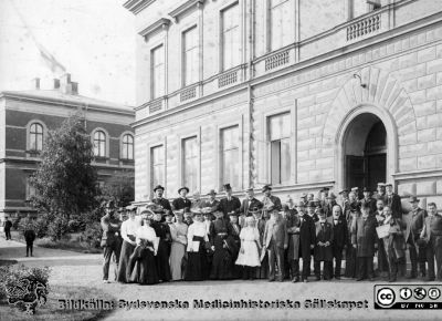 Möte med anatomer (?) i Lund
Kapsel 25	Påskrift: "Universitetet, läkarsammankomster 1903?". Originalfoto utanför dåvarande anatomiska institutionen. Kanske Prof. Carl M. Fürst som nr 2 från vänster på bortre raden? Rimligen ett möte med anatomer. Monterat
Nyckelord: Kapsel 25;Konferens;Lund;Anatomi