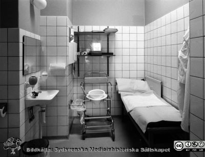 Onkologiska kliniken i Lund. Toalettrum med flyttbar toalettstol och vilobrits.
Foto Ola Terje låda A bild 35/5. Slutet på 1980-talet. Troligen avdelningen för gynekologisk onkologi. 
Nyckelord: Terje;Onkologisk;Onkologi;Klinik;Lund;Interiör;1980-talet;Toalett;Vårdavdelning