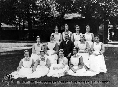 Läkare och personal på medicinska kliniken i Lund c:a 1905
Påskrift: "D:r Emil Lundström (omrkr. 1905): amanuens o underläk vid med. klin. Lund, stadsdistr. läk. i Malmö. Död i hjärtinfarkt 1926." Sofiasystern bör vara Inez Oom (sittande, svart mössband). 
Foto Lina Jonn - Lund. - Foto monterat på pappskiva
Nyckelord: Lundström;Emil;Sofiasyster;Amanuens;Underläkare;Medicinska kliniken;Medicin;Lund;Malm;Foto Lina Jonn;1900-talet;Kapsel 05;Personal;Sköterskor;Gruppfoto