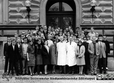 Kursfoto vt 1965 på anatomiska institutionens trappa
Kapsel 27. Fotoarkiv. Anatomiska instutionen. Kursfotografier från 1950- och 1960-talen. Vårterminen 1965. Originalfoto på anatomiska institutionens trappa. Prosektor Folke Löfgren och vaktmästare Tage Silfver i vita rockar på främsta raden. Kursdeltagare enligt den senare listan från med-kand-examen: Leif Engqvist, Per Flodgren, Christer Larsson, Göran Lindskog, Margus Mägi, Britt-Marie Trovik, f. Kälvesten, Sören Vallgren, Sven-Olof Andersson, Sonja Johansson, Mare Kangro, Ingrid Moqvist, Leif Svanström, Annika Sigbrandt, Nils Werner, Lars-Olof Andgren, Kristina Berg, Bengt Esping. Marie-Louise Jönsson, Gunnar Swartling, Hans Bauer, Inger Belfrage, Elisabet Fagerholm, Frans-Thomas Fork, Per-Ebbe Jönsson, Per-Olov Landström, Åke Reimer, Lars Janzon, Fredrik Lindgren, Allan Nilsson, Hans Nilsson, Nils Ingvar Nilsson, Per-Olof Nostell, Bengt Ohlander, Py Persson,Britta Stilvén, Christina Vigre, Stig Areskoug, Eva Nordqvist, Gunilla Byström, f. Widerberg, Lilian Johansson, Bengt Olsson, Ingvar Persson, Per Zenny Rosenquist, Bengt Bengtsson, Birgitta Fredriksson, Lars Peil, Gunilla Bogren, Jörgen Ekström, Olof Magnusson, Margareta Grendal-Johnsson, Marie Louise Olsson, Anders Alwmark, Sune Hallberg, Christer Sylvén, Sven Follin, Åsa Vinnerberg. Omonterat.
Nyckelord: Kapsel 27;Kursfoto;Anatomi