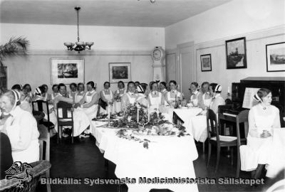 Kaffekalas på Södra Sveriges Sjuksköterskehem
Påskrift: Utb. sjuksköterskor. Foto "Fotokällaren" Lund, Alfr. Hagblom.
- Samlingsrummet på SSSH, gissningsvis 1900-talets första halva eftersom alla har mössa och de flesta också hakband.
Nyckelord: Kapsel 05;SSSH;Sjuksköterskehem;Sverige;Södra;Foto;Hagblom;Lund;Utbildning;Samlingsrum;Fest;Personal