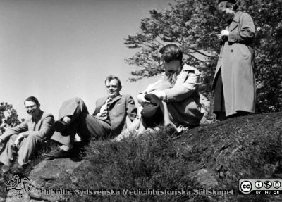 Från en utflykt med medicinare 17/5 1936
Kapsel 28. Bild från kuvert märkt "Fotografier tagna av Elof Munck under studieåren på 1930-talet" och i innerkuvert märkt "Med F på utflykt 17/5 1936". Påskrift på bilden: "Holmberg. Holmdahl. S. Anna Lisa. Jönsson. Kollberg". Namnen på kortet betyder nog vilka som beställt kopior. C. G. Holmberg i randig slips i bildens mitt, senare professor i klinisk kemi i Lund. Originalfoto. Omonterat.
Nyckelord: Kapsel 28;1930-talet;Lund;Utflykt