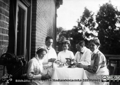 Överläkare Malte Ljungdahl, medarbetare och personal i en kaffepaus
Kapsel 28. Påskrift: Malte Ljungdahl (troligast läkaren i glasögon). SSSH-sjuksköterskor. Originalfoto. ej monterat
Nyckelord: Kapsel 28;Personal;Kaffepas