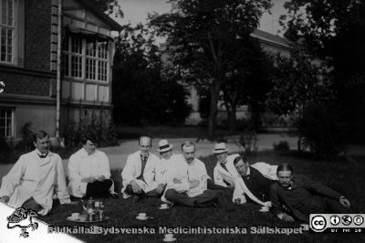 Malte Ljungdahl med kollegor och personal
Kapsel 28. Påskrift "7. Malte Ljungdahl" (dvs mannen näst längst till höger). Han var lasarettsläkare vid Malmö allmänna sjukhus medicinska avdelning 1925-48; dessförinnan verksam vid Lasarettet i Lund. Bilden är tagen vid södra gaveln på dåvarande barnkliniken i Lund. Dåvarande gamla barnbördshuset skymtar mellan träden i bakgrunden, ännu ej påbyggt med en tredje våning, vilket gjordes 1921. Originalfoto före 1921. Omonterat.
Nyckelord: Kapsel 28;Läkare;Lund