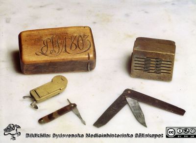 Åderlåtningsinstrument
Kapsel 28. Påskrift: "Ålderlåtningsinstrument, almanacka". Årtalet 1803 inskuret i dosa. Originalfoto. Ej monterat
Nyckelord: Kapsel 28;Kirurgi;Snäppare;Lansett;Etui;Åderlåtning