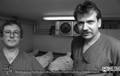 Obduktionsteknikerna Eskil Larsson och Michael Svensson.
Album III 1993 Malmö, från fotograf Björn Henrikssons samling. Foto i Malmö 931005, Ole Formare. Negativ. Ej monterat. Obduktionstekniker i Malmö: Eskil Larsson i glasögon och Michael Svensson.
Nyckelord: Album MAS III 1993;Patologi;Obduktion;Tekniker