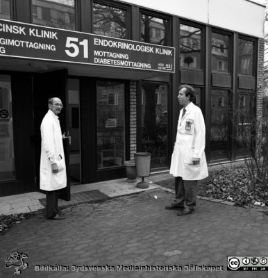 Rolf Ekberg och Per Manhem vid entré 51, medicinsk klinik allergimottagning och endokrinologisk klinik diabetesmottagning 1990.
Album 1990 B i lasarettsfotograf Björn Henrikssons samling. MAS Malmö Allmänna Sjukhus. Omärkt bild. Entré 51 medicinsk klinik allergimottagning och endokrinologisk klinik diabetesmottagning 1990. Rolf Ekberg och Per Manhem, chefsöverläkare, utanför endokrinologiska mottagningen. Negativ
Nyckelord: Album 1990B;MAS;Malmö;Mottagning;Allergi;Diabetes;Endokrinologi;Medicin