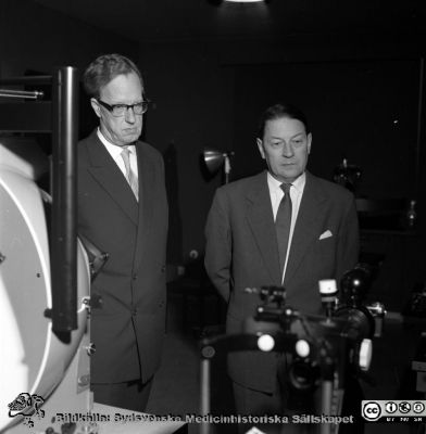 Prof Jan Waldenström och prof Karl-Erik Hogeman på ögonkliniken i Malmö.
Album Äldre neg. 1951-1958 MAS i lasarettsfotograf Björn Henrikssons samling. Kanske i samband med invigningn av bl.a. ögonklinikens nya hus 1961-01-21. Apparaterna är en Goldmann-perimter och en Zeiss ögonbottenkamera.
Nyckelord: Malmö;1951-1958;Invigning;MAS