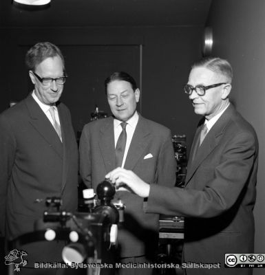 Prof Jan Waldenström, prof Karl-Erik Hogeman och docent Göte Österlind (från 1969 professor) på ögonkliniken i Malmö.
Album Äldre neg. 1951-1958 MAS i lasarettsfotograf Björn Henrikssons samling. Kanske i samband med invigningn av bl.a. ögonklinikens nya hus 1961-01-21. Apparaten är en Zeiss ögonbottenkamera.
Nyckelord: Malmö;1951-1958;Invigning;MAS