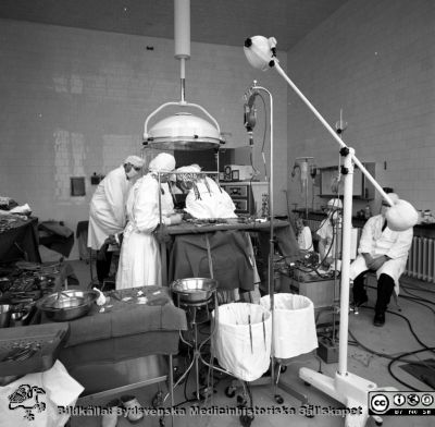 Operation med hjärt-lungmaskin, Malmö 1963
Pärm neg. MAS 1962-1966. Från fotograf Björn Henrikssons samling. Påskrift "Kirurgens OP-salar. 6/2-63". Oxygenatorn är här av den skivtyp som följde efter bubbeloxygenatorn. Denna används på en annan bild tagen samma dag, så kanske var det då man bytte. Från negativ
Nyckelord: UMAS;MAS;Malmö_;Allmänna;Sjukhus;Kirurgi;Operation;Hjärt-lungmaskin;Thorax;Hjärta