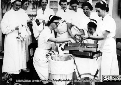 Malmö Allmänna Sjukhus. Instrumentvård.
Instrumenttorkare i aktion på kirurgiska klinikens operationsavdelning. S. Elisabeth Borstam stående nr 3 från vänster. Från samma negativ som bild SMHS7898_000_01Copp.jpg
Från narkospersonalens album till sin chef Olle Lundskog i början på 1980-talet i samband med att han pensionerades, och ställt till Sydsvenska Medicinhistoriska Sällskapets förfogande av dennes dotter Gunilla.
Nyckelord: UMAS;MAS;Malmö;Allmänna;Sjukhus;Sköterska;Instrument;Kirurgi
