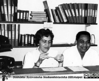 Malmö Allmänna Sjukhus.  
Påskrift: "Asta och främmande burfågel". Ett antal indonesiska kirurger utbildades på 1960-talet i Malmö under Olle Lundskogs och Helge Wulffs tid.
Från narkospersonalens album till sin chef Olle Lundskog i början på 1980-talet i samband med att han pensionerades, och ställt till Sydsvenska Medicinhistoriska Sällskapets förfogande av dennes dotter Gunilla.
Nyckelord: UMAS;MAS;Malmö;Allmänna;Sjukhus;Narkos;Anestesi;Kirurgi