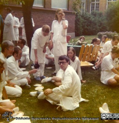 Malmö Allmänna Sjukhus.  Midsommarkaffe i päronträdgården
Personal från kirurgiska kliniken i Malmö. 
Från narkospersonalens album till sin chef Olle Lundskog i början på 1980-talet i samband med att han pensionerades, och ställt till Sydsvenska Medicinhistoriska Sällskapets förfogande av dennes dotter Gunilla.
Nyckelord: UMAS;MAS;Malmö;Allmänna;Sjukhus;Kirurgisk,Narkos;Anestesi;Fest;Personal