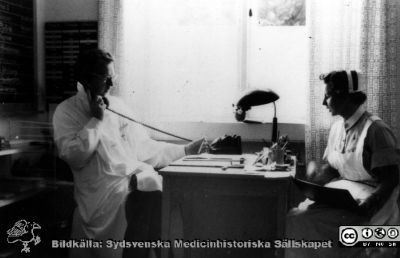 På urologiska kliniken i Lund 1962
Bilder för boken Urologi i Sverige, 1940-1990 av Gustav Giertz. Sid. 263. Underläkaren Lennart Andersson (sedermera professor i urologi) och avdelningssköterskan Maj-Britt Jönsson har överläggning, 1962, urologiska kliniken i Lund. Reprofoto
Nyckelord: Urologi;Avdelning;Vårdavdelning;Lund