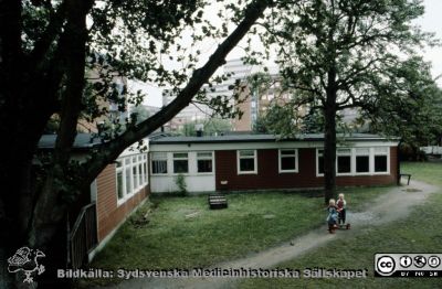 Röda Stugan", Lasarettet i Lunds barndaghem, 1990
Sjukhusets barndaghem i Lund, "Röda Stugan", låg på 1980-talet på tomten mellan infektionskliniken (i bakgrunden) och barnkliniken, dvs strax väster om radiologiska kliniken. När denna skulle utvidgas västerut flyttades barndaghemmet till tomten öster om ögonkliniken B, söder om psykiatriska kliniken (senare kallad Wigerthuset). Barndaghemmet dokumenterades inför flyttningen.
Nyckelord: Lasarettet;Lund;Universitet;Daghem;Barndaghem;Förskola