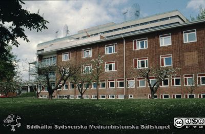 Ögonklinikens söderfasad i början på 1990-talet
Ur låda med blandade diabilder från sjukhusfotograferna i Lund, 1970-, 1980- och 1990-talen. Foto efter ombyggnaden 1986 och medan ännu de stora satellitantennerna stod kvar på C-blockets tak. De togs ned före 1995. Ronald McDonald Hus har ännu inte byggts. Foto rimligen i början på 1990-talet.
Nyckelord: Lund;Lasarett;Universitetssjukhus;USiL;Park;gon;Klinik;Fasad;Park.