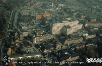 Lasarettet i Lund från söder, c:a 1990
Flygfoto av Lasarettet i Lund från sydväst, c:a 1990. 1993 års strålningsavdelning är inte byggd, liksom inte någon del av BMC. Ögonkliniken är renoverad (1986) och har ett stort ljust fläkthus på taket.
