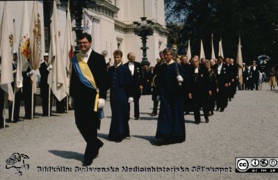 Promotionsprocessionen lämnar universitetshuset på väg till domkyrkan våren 1989
Promotionsprocessionen lämnar universitetshuset på 1980-talet. Göran Larssson i blågult band leder denna del av tåget. Bakom skymtar Rector Magnificus Håkan Westling, kommunalrådet Lennart Prytz, juristprofessorn Kjell Åke Modeer, biskop Per Olov Ahrén, professor Philip Sandblom (vithårig), länsrådet Lennart Linder-Aronson, domprost och senare ärkebiskop K G Hammar.
Nyckelord: Lund;Universitet;Doktor;Promotion;Procession