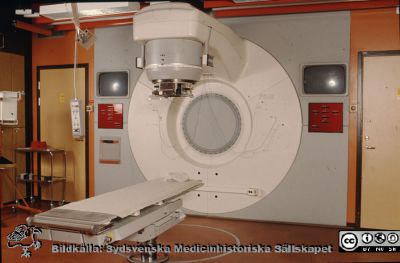 Radiologiska / onkologiska kliniken i Lund. Strålbehandlingsmaskin
Ur låda med blandade diabilder från sjukhusfotograferna i Lund, 1970-, 1980- och 1990-talen. Omärkt bild. En Philips SL75-25-maskin, installerad i Lund i mitten av 80-talet. Bordet, som kallades ”RAM-bord”, kunde sänkas mycket långt ner tack vare att det fanns en två meter djup grop under golvet.
Nyckelord: Lasarett;Lund;Universitetsklinik;USiL;Radioterapi;Röntgen;Onkologi;Högvolt;Behandling