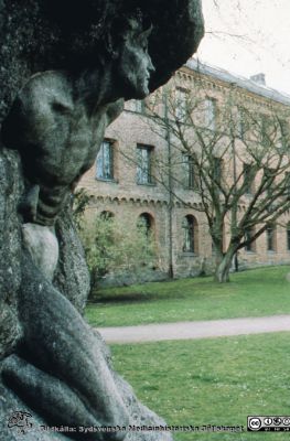 "Mannen som bryter sig ur klippan". Universitetsplatsen i Lund med Kungshuset i bakgrunden.
Skulptur av Axel Ebbe, skänkt till Universitetet vid 250-årsjubileet 1918. Klippan symboliserar okunnighetens mörker som den kraftfulle mannen / studenten bryter sig ut ur.
Nyckelord: Lund;Universitet;Park