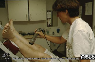 Avdelningen för klinisk fysiologi på 1980-talet
Bild utan beskrivning. Gunnel Olsson, lärare i hälso- och sjukvård, demonstrerar undersökning vid misstänkt djup ventrombos med en isotopmetod. Isotopen injicerades intravenöst och en hög halt av isotop i benet visar att det finns ökad volym venblod i benet. Tiden är nog i början av 80-talet.
Nyckelord: Lasarettet;Lund;Laboratorium;Underben;Universitet;Universitetsklinik;USiL;Klinisk fysiologi