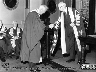 Professor Philip Sandblom promoveras till hedersdoktor vid ett universitet i Storbrittannien
Philip Sandblom, Rector Magnificus vid Lunds universitet emottar någon utmärkelse vid vad som förefaller vara en akademisk ceremoni vid något europeiskt universitet. Det kan handla om hedersdoktorat i Glasgow 1965 eller kanske i Paris 1967.
Nyckelord: Kapsel 01 Regionarkivet