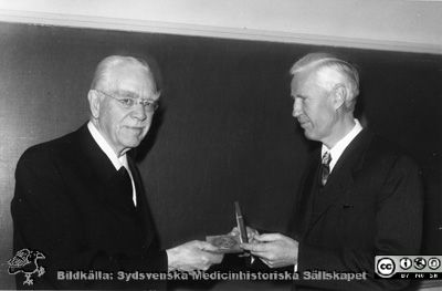 Professor Gustaf Petrén får medalj av Philip Sandblom 1958
Omonterat fotografi. Påskrift: "Prof. o. öl., LL. MS4840. Maj 1958." Svårtytt: "Werner fred. 491/68K. Petren". Bilden visar professorn i kirurgi, Philip Sandblom, till höger, överräckande en medalj till en tidigare professor i kirurgi i Lund, Gustaf Petrén (1874-1962).
Nyckelord: Kirurgi;Lund;Klinik;Universitet;Universitetssjukhus;Lasarett;Hedersbetygelse