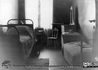 Ett enkelrum för patient på ögonkliniken i Lund i mitten på 1920-talet. 
Fotografi monterat på albumblad.  Från ett album gjort till professor Gustaf Ahlström inför hans pensionering 1927.
Nyckelord: Ögon;Klinik;Lasarettet i Lund;Medicinska fakulteten;Halvenskilt;Sjukrum;Vårdrum