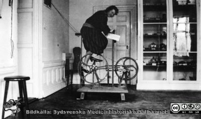 Magnus Blix' trampergograf, byggd c:a 1900. 
Senare har den också kallats trampmyograf eller trampdynamometer. Foto på fysiologiska institutionen 1923. Bilden visades på en utställning av apparater från fysiologens verkstad under andra halvan av 1900-talet med vernissage på Livets MUseum i Lund 2013-05-28.
Nyckelord: Lund;Livets Museum;Utställning;Fysiologiska;Institutionen