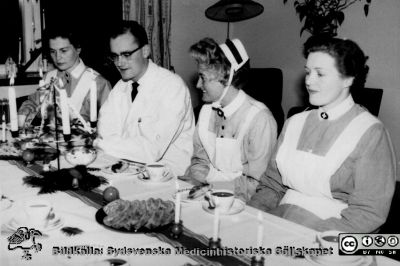 Julkaffe 1957 på Malmö Allmänna Sjukhus, på medicinklinikens privatavdelning
Julkaffe på personalrummet på privatavdelningen (avd. F / 8) på Malmö Allmänna Sjukhus 1957. Dåvarande underläkaren John "Johnte" Dymling (1931 - 2007) tillsammans med avdelningspersonal. SSSH-sköterskan med hakband och mössa är syster Lilian. Foto av avdelningssköterskan Inez Kronvall (1909-1996); från hennes brorson Göran Kronvall.
Nyckelord: Malm;Allmänna;Sjukhus;UMAS;Internmedicinsk;Klinik;Julkaffe;Privatavdelning