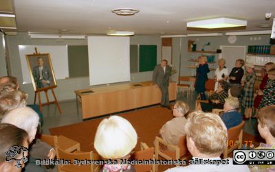 Urologiska klinikens 20-årsjubileum 1977-10-01
Album Urologiska klinikens 20-årsjubileum 1977-10-01. Professor Gösta Jönssons porträtt framvisas. Gösta Jönsson själv vid katedern. På främre stolsraden i ljusbrun kostym med ryggen mot kameran: Professor Lennart Andersson, Stockholm. Övriga sittande är ej identifierade. Stående vid bortre väggen, från vänster: okänd, okänd, sjuksköterkan Anna-Breta Hammarberg (röntgen; i ljusa kläder), Sjuksköterskan Marianne Nilsson (mörk polotröja och glänsande halsband), nattsjuksköterkan Carin Lundblad (rutiga kläder), sjukvårdsföreståndaren Mary Mattsson ( röda kläder och avdelningsföreståndare Eva Ljunggren i stormönstrad klänning, längst till höger. Bildkälla: Bengt Uvelius.
Nyckelord: Lasarettet;Lund;Universitetssjukhuset;USiL;Urologiska;Kliniken