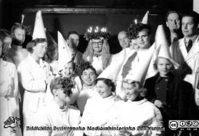 Patologiska institutionen på Paradisgatan före 1962. Luciafest.
Ur CG Ahlströms album Institutionen för Patologi, Paradisgatan, Dess chef och personal 1944 - 1962. Luciafest i slutet på 1950-talet. CG Ahlström i bakre ledet, strax till höger om "Lucia". Strax till vänster om "Lucia" i bakersta ledet kanske Folke Linell. Längst till höger kanske Nils Oskar Berg.Tillhörande text på albumbladet: 
Stilla är stjärna
tom är nu hjärna
änglar med rosig kind
mot dagen spjärna.
Värna dem mot id
tärna giv dem tid
ansa sin nia
Santa Lucia
(Kan med viss anpassning sjungas till "rätt" melodi, den svensa luciasången.
Nyckelord: Lasarettet;Lund;Universitetssjukhuset;USiL;Patologiska;Institutionen;Avdelningen;Anställda;Personal;Luciafest