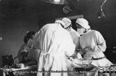 Reprofoto i samband med Lasarettet / vårdcentralen / länssjukhemmet i Hörbys 100-årsjubileum 1979-10-12.  
Operation 1946. Doktor Wadstein opererar, assisterad av en underläkare, syster Margit och Birgit Wernersson. Bildkälla: ett fotoalbum på vårdcentralen i Hörby med bilder från lasarettet / vårdcentralen i Hörbys 100-årsjubileum 1979-10-12.
