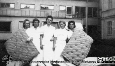 Reprofoto i samband med Lasarettet / vårdcentralen / länssjukhemmet i Hörbys 100-årsjubileum 1979-10-12.  
Storstädning på 1940-talet på lasarettet i Hörby innebar att alla madrasser skulle ut på gården och piskas. Städlaget betår av från vänster Olga Göransson, Olga Persson, Silma Retinnen, Edit Rosenlund och Anna-Greta Hansson. Bildkälla: ett fotoalbum på vårdcentralen i Hörby med bilder från lasarettet / vårdcentralen i Hörbys 100-årsjubileum 1979-10-12 (1).
Nyckelord: Lasarett;Hörby;Storstädning