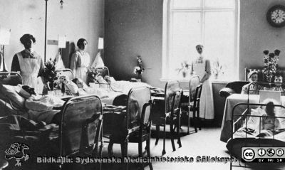 Interiör från en sal på medicinska kliniken med Syster Sofia vid fönstret.
Från en kontorspärm på Medicinhistoriska Museet i Helsingborg märkt "Äldre fotografier från med. + kir.klin.”. Foto troligast under 1900-talets två första decennier. Interiör från en sal på medicinska kliniken med Syster Sofia vid fönstret.
Nyckelord: Lasarettet;Helsingborg;Klinik;Medicinsk;Vårdsal