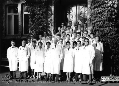 Medicinarkursen i kirurgi i Lund höstterminen 1959, med klinikens läkare och lärare. 
1: Lars Cederqvist. 2: Håkan Odeberg. 3: Ingrid Walldén, 4: Elsa Ryde. 5: Eva Hjelmqvist. 6: Philip Sandblom. 7: Anita Torsdotter, 8: Per Vegfors, 9: Doc. Stig Borgström, 10:  Jan-Erik Rosengren, 11: B.-G. Svensson. 12: Sven-Olof Isacsson. 13: S. Andersson. 14: R. Svensson? 15: Christer Behring. 16: J. A. Josefsson. 17: Birgitta Borulf. 18: Dan Elmqvist. 19: Arne Bendz. 20: Jan Spjuth. omärkt: Lars Göran Lindberg. 21: Bertil Niklasson. 22: doc. Gösta Jönsson. 23: doc. Eric "Nilla" Nilsson. 24: dr. Eric Lindstedt? 25: Okänd. 26: Okänd. 27: doc. Lars Röhl. 28: dr. Bengt Åke Åkesson? 29: dr. Orvar Johnsson? 30: dr. Lars Nordström?? 31: doc. Göran Lundh. 32: doc. Lennart Andersson. 33: Okänd. 34: doc. Carl Axel Ekman. 36: Okänd. 
Fotografi av hovfotograf Jensen, Lund.
Nyckelord: Lasarettet;Lund;Universitetssjukhuset;USiL;Kapsel 04;Kirurgisk;Klinik;Kurs