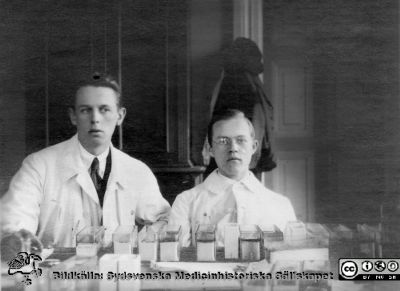 Bilder från histologiska avdelningen på anatomiska institutionen i Lund år 1923
Fotoalbum märkt 1923 på första bladet. Det innehåller bilder från dåvarande histologiska avdelningen på anatomiska institutionen i Lund på Biskopsgatan 7. Bildtext: Rikard Helmer. Erik Millbourn.  
De  förefaller sitta i i histologens kurslaboratorium för att färga histologiska preparat. 
Bildkälla Stiftelsen Locus Medicus Lundensis 250317. Fotograf okänd.
Nyckelord: Histologiska avdelningen;Anatomiska Institutionen;Locus Medicus Lundensis;Stiftelse;Medicinska fakulteten i Lund;Lunds universitet;Medicine studerande;Studenter;Kurslaboratorium