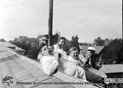 Fotoalbum märkt Histologikursen Ht. -27 på första bladet. 
Fotoalbum märkt Histologikursen Ht. -27 på första bladet. Det innehåller bilder från dåvarande histologiska avdelningen 
på anatomiska institutionen i Lund på Biskopsgatan 7. Bildtext "Amanuensglädje på taket",  men saknas i övrigt. Bilden ett antal törstiga amanuenser och en student i studentmössa på institutionens tak. 
Bildkälla Stiftelsen Locus Medicus Lundensis 250317. Fotograf okänd.
Nyckelord: Universitet;Pilsnerfest;Anatomiska Institutionen;Histologiska avdelningen;Lärare;Amanuenser;Studenter